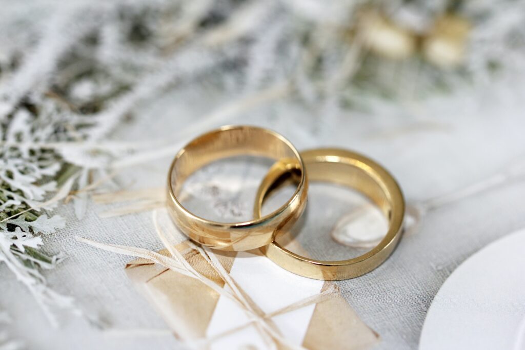 two weeding rings overlapped on one another, placed on top of a grey table cloth